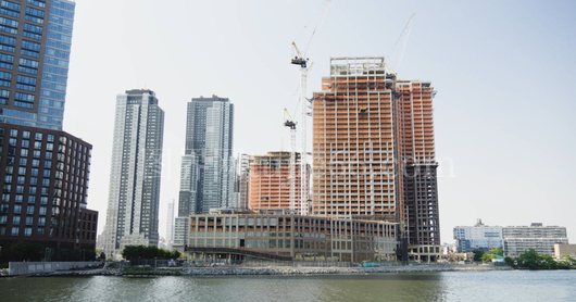 曼哈顿河岸高楼建设三起重机映衬