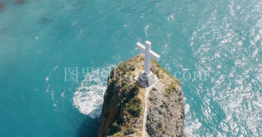 海中岩石上的十字雕塑
