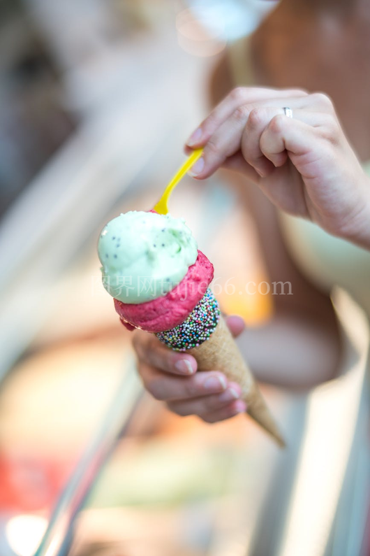 女性手握彩色糖霜冰淇淋特写