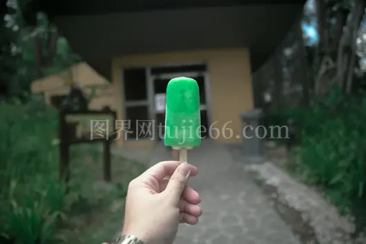 人物手持绿色户外冰棍模糊背景