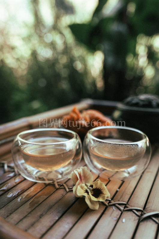 竹桌玻璃杯热茶三色堇