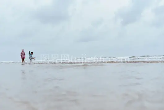 海滩岸边两童嬉戏