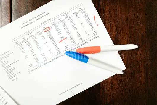 顶部视角财务文件红笔标注木桌图