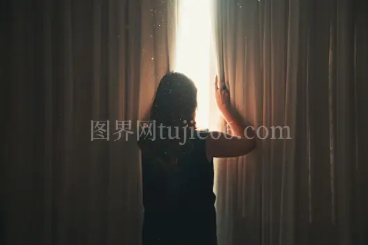 公寓内神秘女士拉亮光窗帘