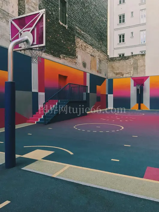 混凝土建筑旁多彩篮球场白昼景致