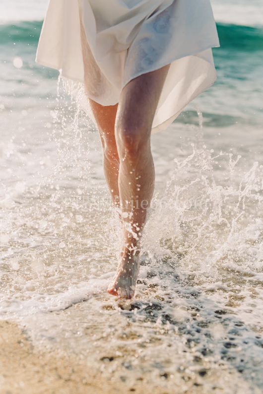 女性赤脚海边水花漫步