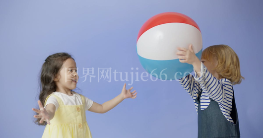 海边两童嬉戏沙滩球