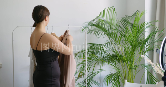 少女挂大衣衣架间