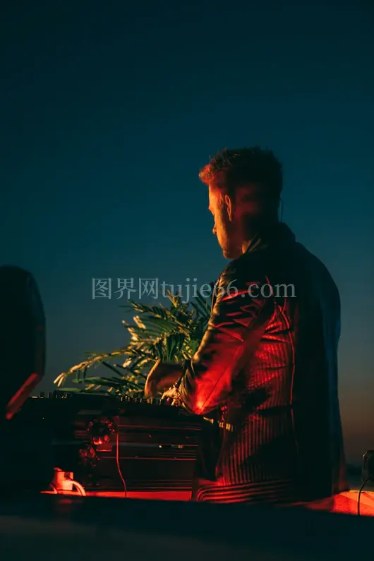 男子穿黑夹克白天绿植旁