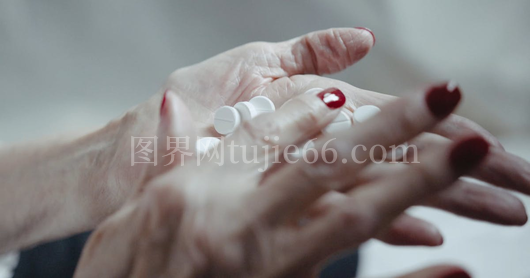 女性手握药片红指甲生活之美