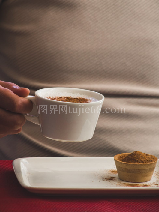 手捧肉桂咖啡杯特写