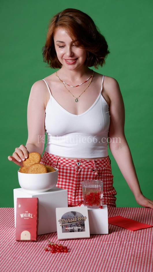 微笑女士红色格子裙伸手拿饼干