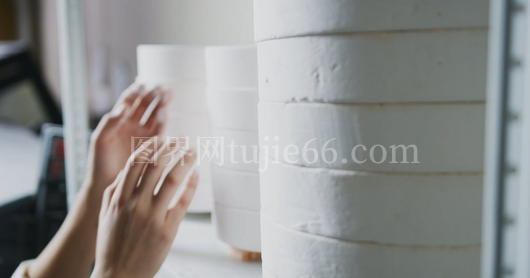 女性手握白瓷器