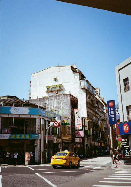 黄色汽车穿行高楼街景